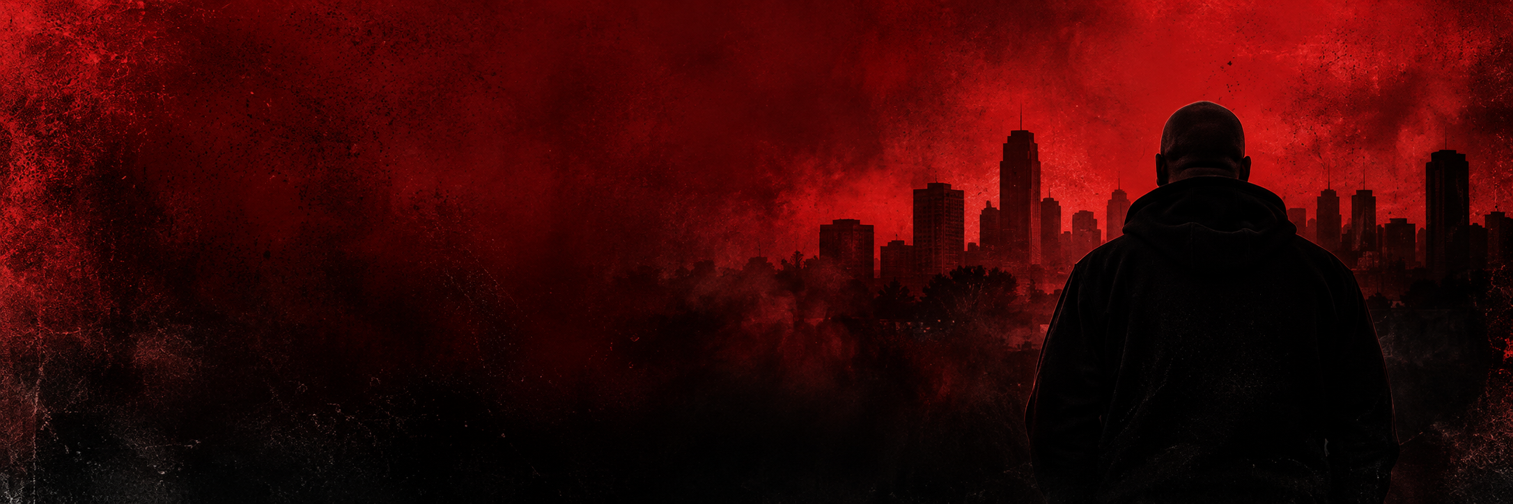 A hooded figure looking toward a city skyline under a red sky